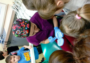 Pani stomatolog pokazuje dzieciom jak zakłada się plombę na zęba